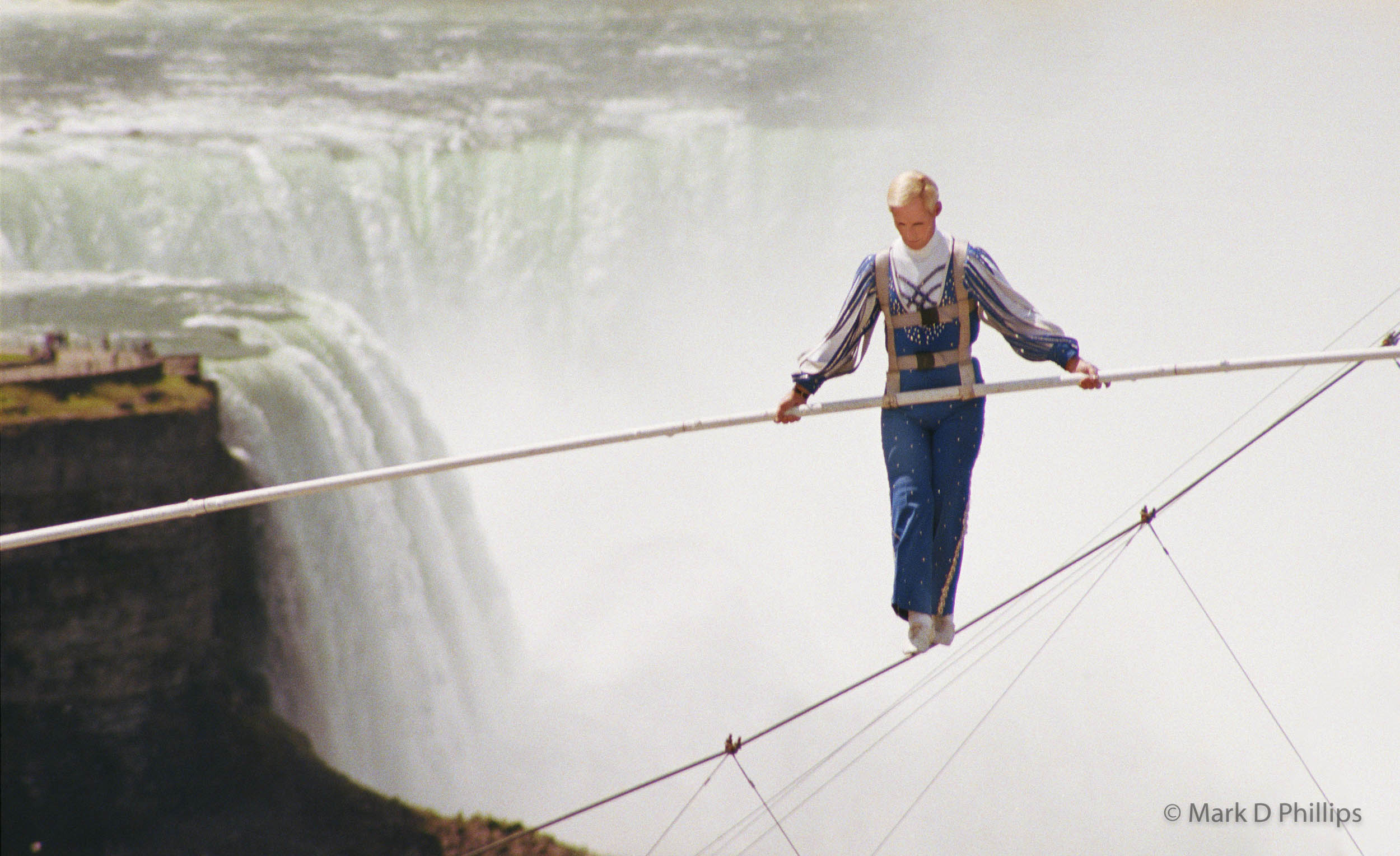 Jay Cochrane skywalks on Clifton Hill in Niagara, Canada, in 2002. The first skywalk in over a hundred years went from the pinnacle of the Sheraton on the Falls Hotel to the Casino Niagara Tower at a height of 40 stories, with Niagara Falls as the backdrop. "Skywalk at Niagara" was the highest skywalk ever completed in Niagara Falls. ©Mark D Phillips