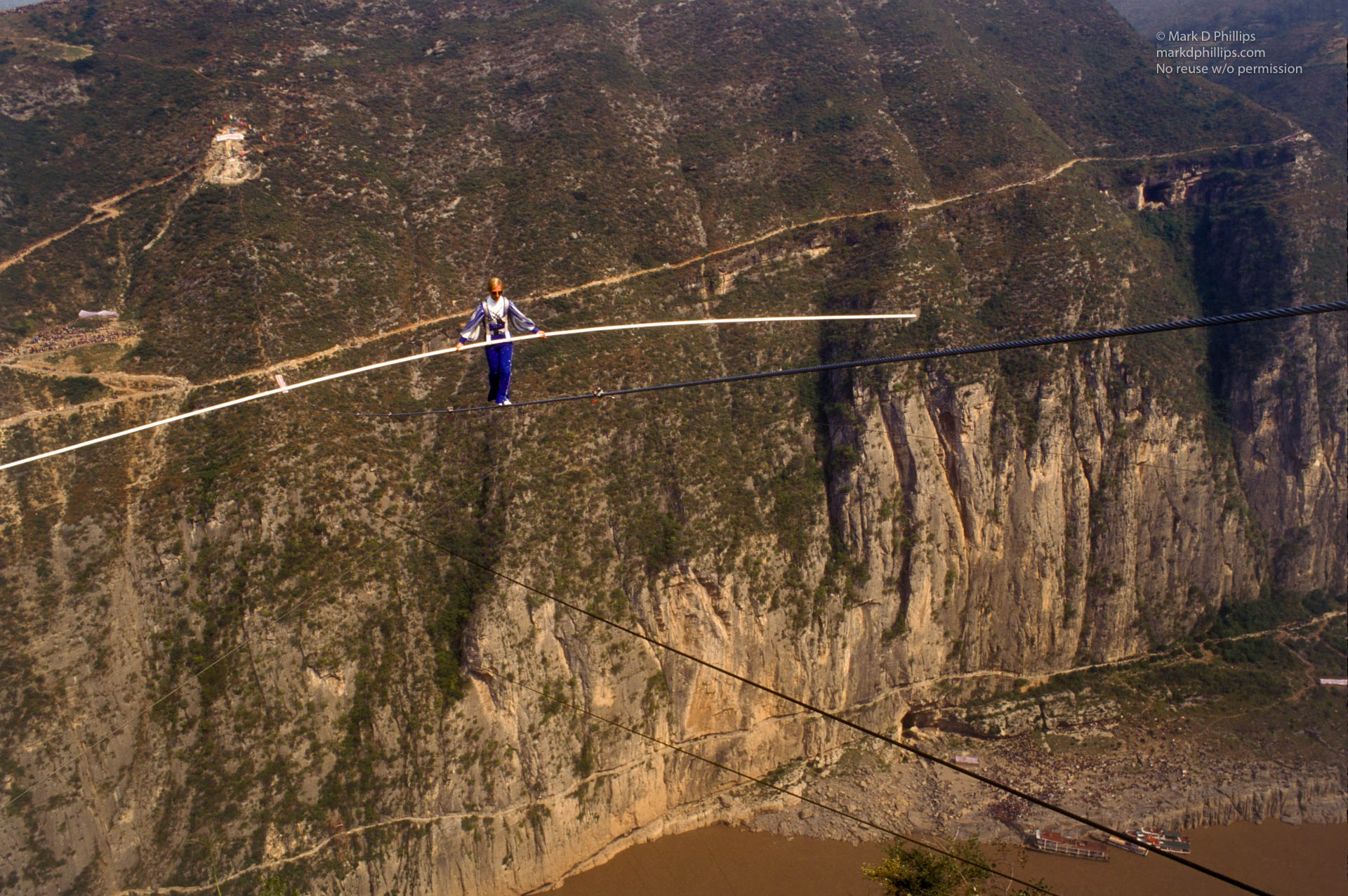 Jay Cochrane, "The Prince of the Air", walks on a cable over the Yangtze River in Qutang Gorge, China, on October 28, 1995, during The Great China Skywalk . The skywalk was and is the greatest highwire walk ever made spanning half a mile between the canyon walls and 1,350 feet above the river. Thousands of spectators lined the trails within the legendary Three Gorges of the Yangtze. The gorges are now filled with water with the completion of the Three Gorges Dam, creating a 500-foot deep reservoir in Qutang Gorge. Photo by MARK D PHILLIPS